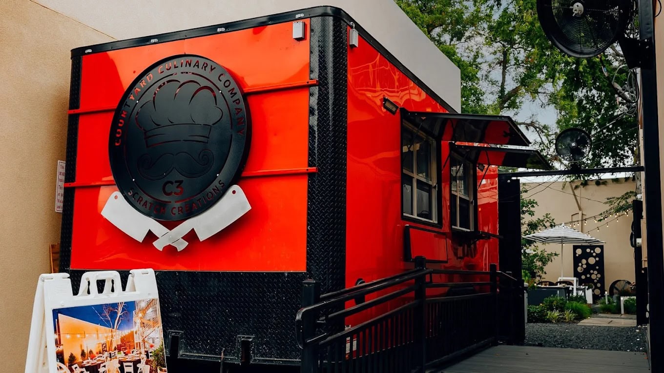 Red food truck with black accents and a large logo on the side.